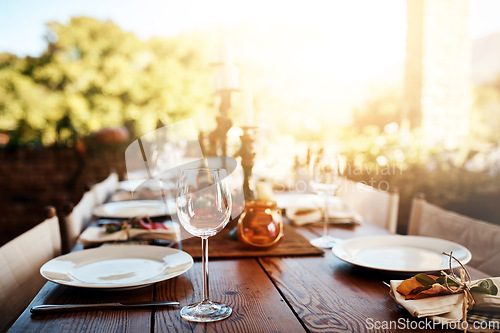 Image of Thanksgiving, dinner table and decoration for a party, banquet or celebration in the backyard. Plate, wine glass and decor with a rustic elegant dining set, cutlery and tableware outside feast.