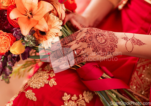 Image of Henna, hands and Indian woman at her wedding event with flowers or bouquet for decoration or design. Luxury, marriage and traditional culture by a bride with art pattern on her hand for celebration