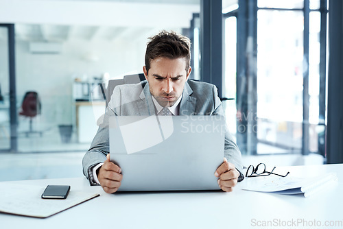 Image of Stress, frown and angry man on laptop in office frustrated with glitch, mistake or crisis. Anxiety, face and business person with failure or problem, 404 or bad review, deadline report or tech delay