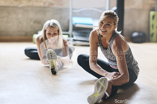 Image of Portrait, smile and women on the floor, stretching and energy with confidence, workout goals and training. Female person, friends and girls in a gym, stretch legs and exercise with balance and health