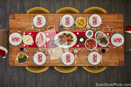 Image of Dinner, table and Christmas lunch with food at an event from top view or above of a home dining room for celebration. Chicken, party and holiday or vacation vegetables and meat for fine dining