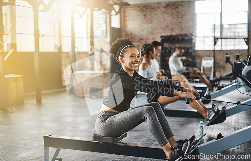 Image of Group, rowing machine and training in gym, class or fitness workout, exercise or cardio, row team and practice. People, healthy athlete and challenge on sport equipment, row crew and sports club