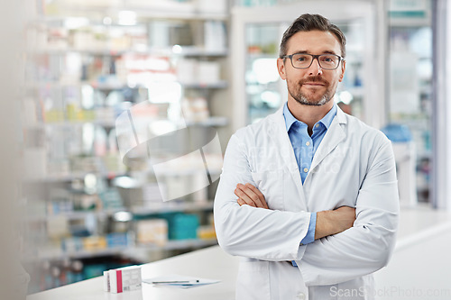 Image of Healthcare, crossed arms and portrait of a male pharmacist standing in a pharmacy clinic. Pharmaceutical, medical and mature man chemist with confidence by the counter of medication store dispensary.