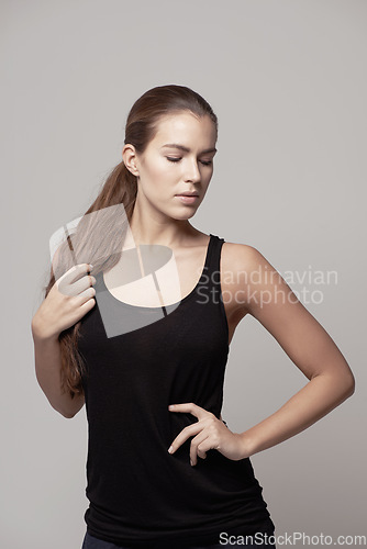 Image of Woman, fitness and confidence for exercise, workout or training with sportswear against a gray studio background. Confident female person or model posing with slim and healthy body on backdrop