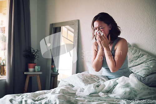 Image of Home, tissue and woman with the flu, allergy and sick in her apartment, couch and suffering. Female person, blowing nose or girl in her bedroom, health issue and illness with pain, tired or exhausted