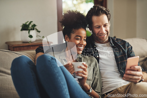 Image of Home, relax and interracial couple on a couch, smartphone and happiness with connection, mobile app and social media. Partners, happy man and woman with a cellphone, communication and online reading