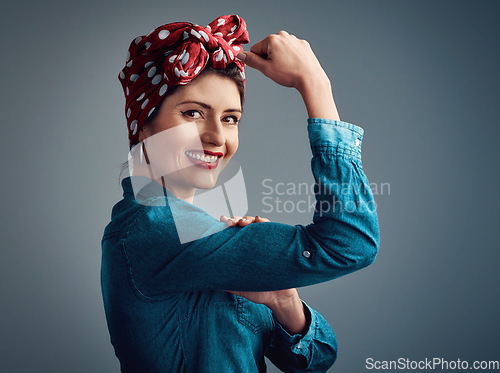 Image of Strong, pinup girl and flexing muscle portrait of a woman in studio for beauty, power and fashion. Happy female person show bicep on grey background for motivation, freedom and retro or vintage style