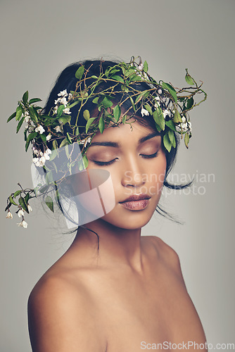 Image of Beauty, flowers and crown with a woman in studio on a gray background for natural skincare or treatment. Skin, nature and wellness with an attractive young female model wearing a flower wreath