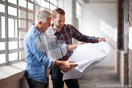 Image of Architect, teamwork and holding blueprint for reading, planning or analysis of real estate development. Men, paper and design at property, construction site or building with talk, discussion or help