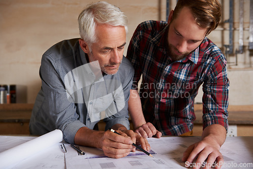 Image of Architecture team, work on blueprint in workshop with designer and engineering collaboration. Senior architect with male trainee, working on remodeling project with floor plan paperwork and drawing