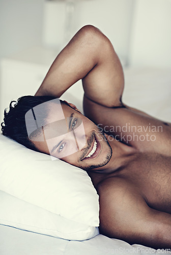 Image of Portrait, happy and morning with a sexy man in bed, shirtless after a rest to relax while ready to wake up. Face, smile and body with a handsome or sensual young male model lying topless in a bedroom