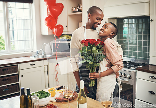 Image of Flowers, love and valentines day with a black couple in the kitchen for a romantic celebration together. Food, gift or romance with a man and woman bonding in their home during a special event