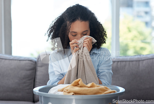 Image of Smelling laundry, fresh and a woman on the sofa with a basket for organizing linen and clothes. Comfort, house and young cleaner with satisfaction from the smell of clean clothing in the living room