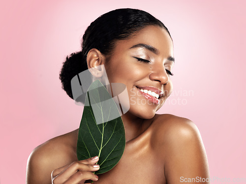 Image of Happy woman, green skincare and natural leaves in studio, pink background or eco friendly aesthetic cosmetics. Face, african model and beauty from plants, leaf and sustainability of vegan dermatology