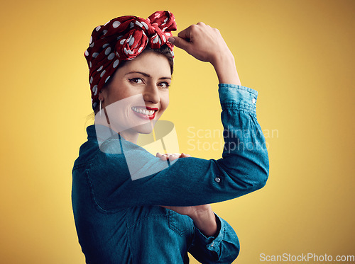 Image of Strong, pinup girl and flexing muscle portrait in studio for beauty, women power and fashion. Happy female person show bicep on yellow background for motivation, freedom and retro or vintage style