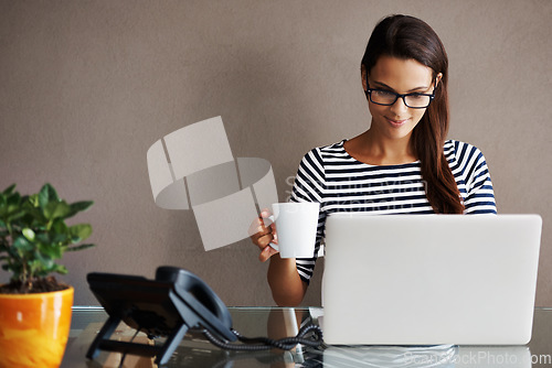 Image of Laptop, coffee and happy business woman in office smile, satisfied and content against a wall background. Tea, research and female worker online for planning, browsing and creative inspiration