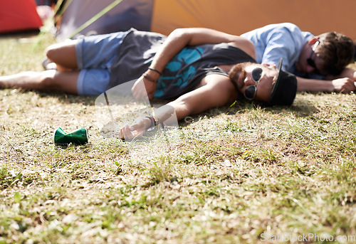 Image of Drunk, sleeping and men on camping ground at a music festival with alcohol. Field, drinking and lawn with a tent and youth on grass with people and man camper at concert outdoor with cans