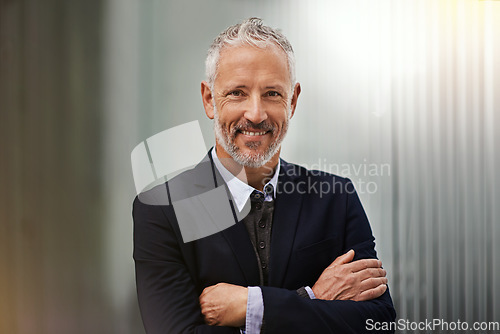 Image of Portrait, vision and arms crossed with a business man in his office, looking happy about his company growth. Mission, mindset and confidence with a senior male corporate manager standing at work