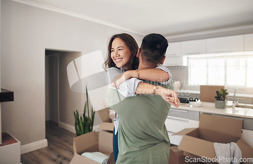 Image of Property, happy couple moving into their new home and boxes in living room. Happiness or smiling, mortgage or homeowners and people hugging celebrating with their new house or apartment together