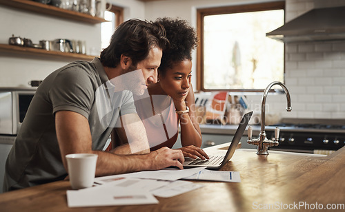 Image of Laptop, couple and financial planning in a kitchen with documents for budget, savings and paying bills. Interracial, online and people with paperwork for taxes, mortgage and home loan application