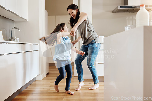 Image of Happy, dance and a child with a mother in the kitchen, bonding and quality time together. Smile, laughing and a mom teaching her daughter with dancing, love and happiness with fun in a house