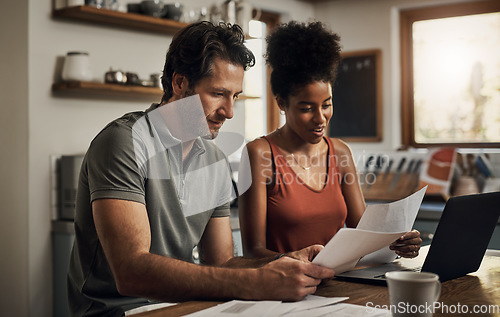 Image of Finance, couple and laptop in a kitchen for planning, budget and savings or paying bills together in their home. Marriage, online and people with documents for tax, mortgage or home loan or insurance