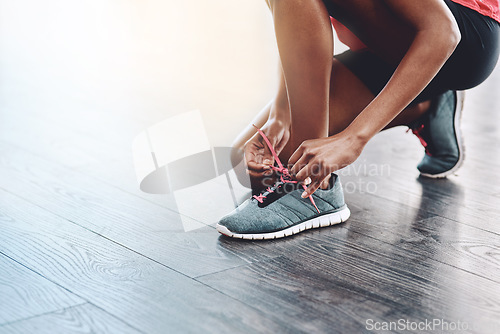 Image of Sneakers, fitness and person tie laces to start exercise, workout or wellness sport in a gym for health performance. Shoes, space and hands of a healthy woman or runner ready for training or sports