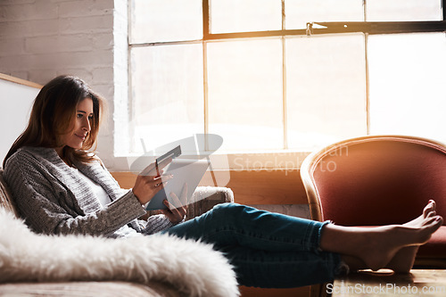 Image of Relax, tablet and credit card with a woman banking online on a sofa in the living room of her home. Ecommerce, financial freedom and shopping with a young female customer or consumer in her house