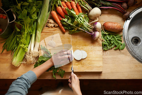 Image of Top view, vegetables and chopping board with hands, cutting and prepare healthy meal. Hand, knife or kitchen utensils with vegan diet, nutrition and organic ingredients with vegetarian dinner at home