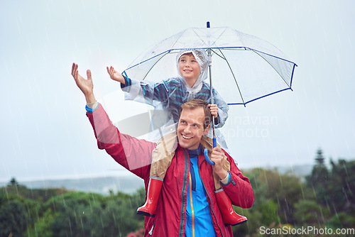 Image of Other, child or family with an umbrella in rain weather outdoor for fun, happiness and quality time. Man and boy kid in nature with protection from water drops with freedom while playing in winter