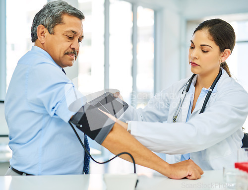 Image of Doctor, man and patient with test, blood pressure and consultation with healthcare, office and checkup. Female person, senior male and medical professional with equipment, hypertension and wellness