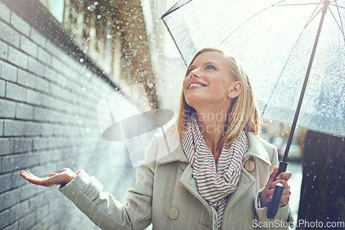Image of Smile, woman and raindrops in the city with umbrella, freedom and happiness on holiday. Winter weather, raining and urban street with a young female person on a sidewalk and vacation outdoor