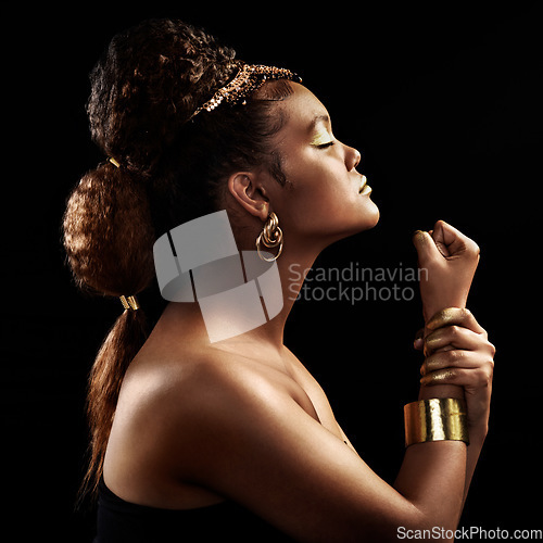 Image of Power, culture and side profile of a woman with a fist isolated on a black background in a studio. Fashion, creative and a young girl with strength, empowerment and tribal or traditional jewelry