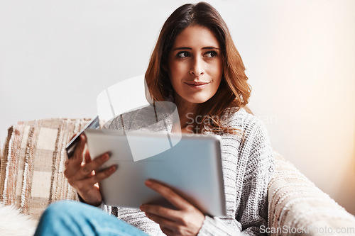 Image of Idea, tablet and online customer with a woman shopping using a credit card on a sofa in the living room at home. Ecommerce, finance and internet banking with a young female shopper in her house