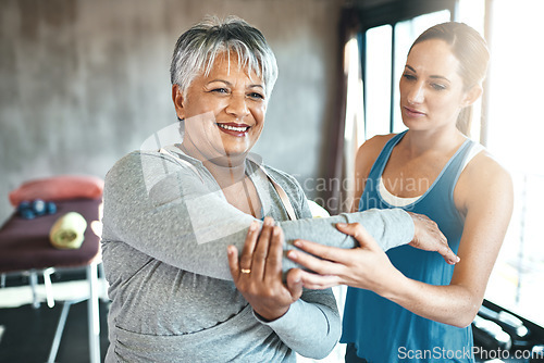 Image of Stretching, support and old woman with personal trainer for fitness, wellness or rehabilitation. Health, workout or retirement with senior patient and female trainer in gym for arm warm up training