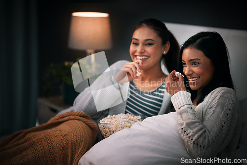 Image of Laughing, popcorn and women watching tv, movies or show at home for sleepover with streaming service and comedy. Gen z people relax in bedroom with funny TV film, cinema subscription and internet