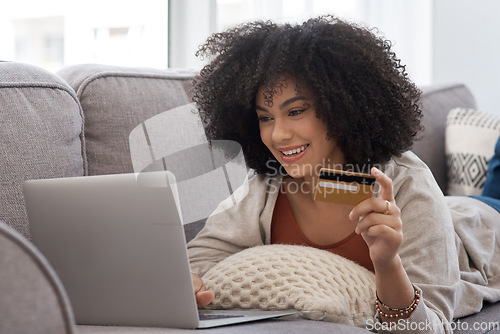 Image of Couch, laptop and woman with a credit card, online shopping and ecommerce with happiness, home and discount. Female person, customer or client on a sofa, technology and retail with payment and buying