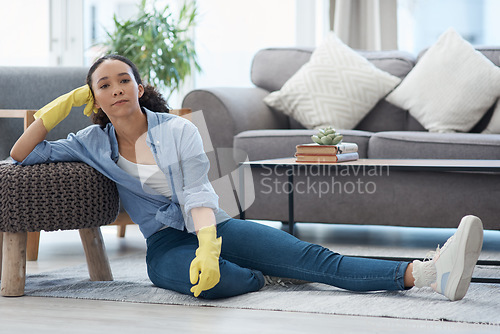 Image of Woman, portrait and cleaner relax after cleaning living room, housekeeping and tired housekeeper at home. Serious female person on break, clean house with hygiene and gloves for safety from bacteria