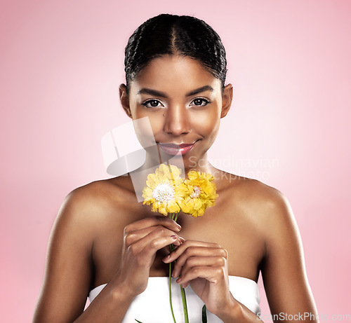 Image of Portrait, woman and flowers for skincare in studio, pink background and eco friendly cosmetics. Face, african model and natural beauty with yellow daisy, plants and sustainability for floral blossom