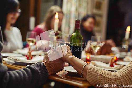 Image of Family, people holding hands in prayer and at dinner table with champagne. Praying for food, support or love and adults gather for celebration or thanksgiving in dining room at their home.