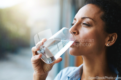 Image of Drinking water, glass and woman thinking of healthcare, wellness and self care at home. Fresh, clean liquid and african person in window of her house with vision for health, diet and nutrition