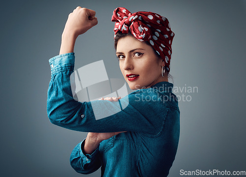 Image of Flexing, strong and portrait of a pinup girl with muscle in studio for support, women power and fashion. Female person show bicep on grey background for motivation, freedom and retro or vintage style