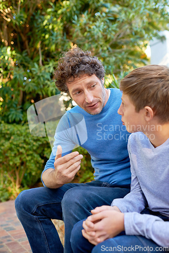 Image of Family, father has talk with son in backyard, bonding with love and care, communication and relationship. Man with boy at home, relax in nature with conversation and spending quality time outdoor
