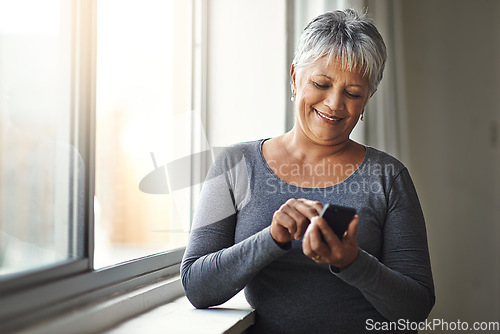 Image of Window, smile and senior woman with a smartphone, connection and social media at home. Mature female, person and old lady with a cellphone, email and mobile app with network, happiness and typing