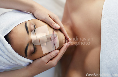 Image of Woman, hands and face in relax for massage, skincare or beauty spa treatment on bed above at resort. Top view of female relaxing with eyes closed for calm therapy, healthy wellness or cosmetic facial