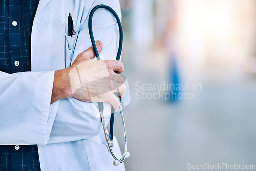 Image of Healthcare, crossed arms and closeup of a doctor with a stethoscope in a hospital with mockup space. Career, professional and zoom of a male medical worker hand with equipment in a medicare clinic.