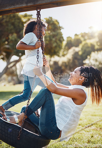 Image of Mother, daughter and happy on swing at park, fun and playing together with smile outdoor. Love, care and bonding with family happiness, woman and girl enjoy time at playground with freedom in nature