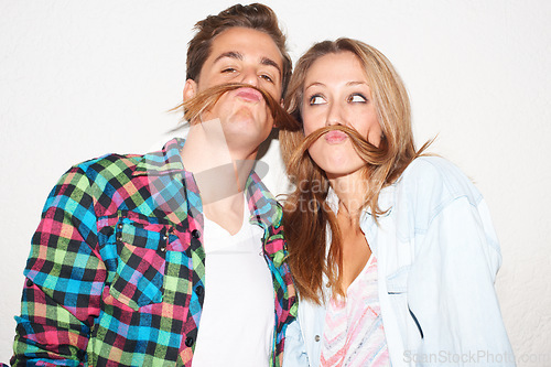 Image of Quirky, portrait and couple with hair moustaches being funny, comic and playful together in a studio. Crazy, young and a man and woman being silly and goofy on a date isolated on a white background