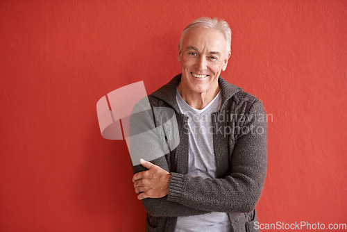 Image of Happy senior man, portrait and red background in retirement with smile, arms crossed and fashion. Elderly guy, happiness and confidence by wall with excited face for lifestyle, experience and relax