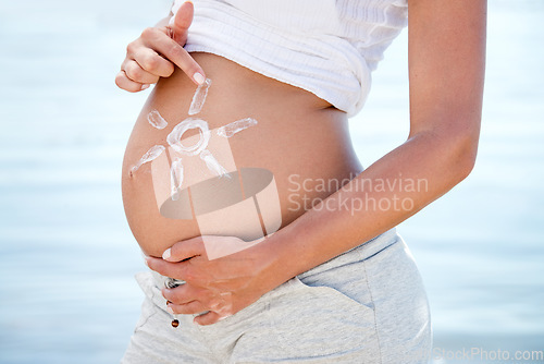 Image of Pregnant, sunscreen and a woman on the beach during summer for sun protection or care on holiday or vacation. Mother, skincare and pregnancy with female tourist outdoor to apply sunblock to her belly